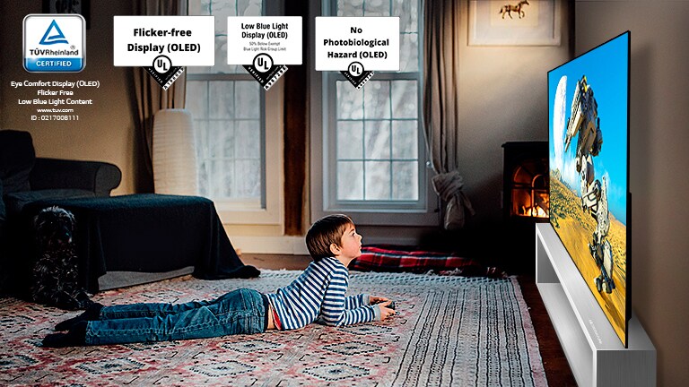 Child lying on the floor, holding a joystick and playing a game on a TV screen