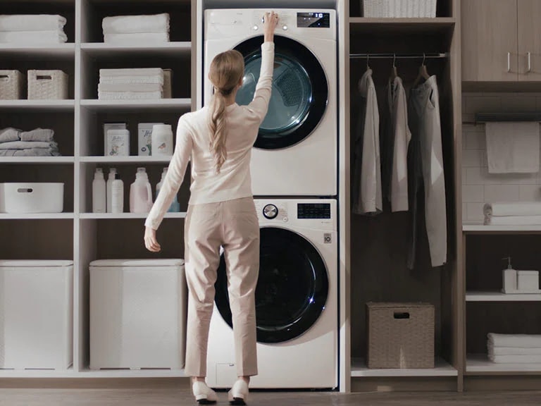 A woman is manipulating the panel at the top of the product with her arms raised.