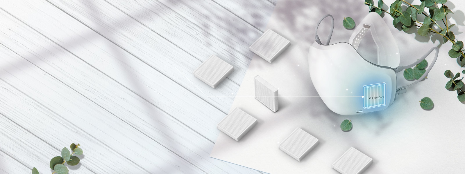 The LG PuriCare Wearable Air Purifier viewed at an angle from the top with H13 Grade HEPA filters scattered around on the table around it. The place to insert the filter on the mask is highlighted with a blue square.