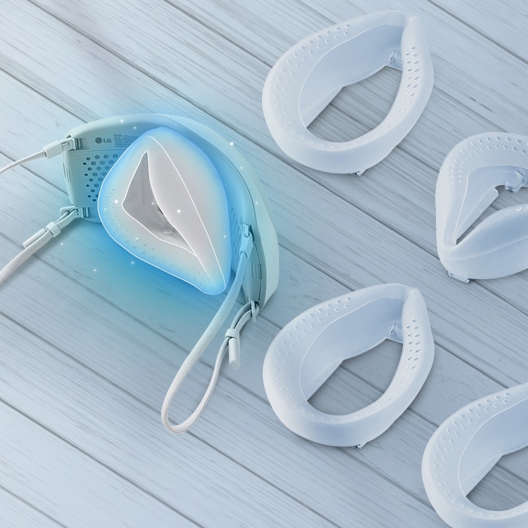 The top and slight interior of the mask is shown with the inner cover inside and silicone pads are spread on the table around it. The place to put the silicone pad inside is highlighted in blue.