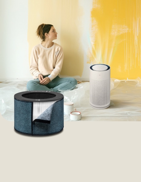 LG air purifier with a formaldehyde filter running next to a woman admiring her paintings in the background.