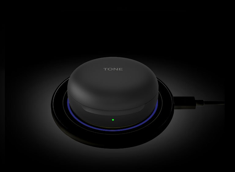 An image of a white LG TONE Free FN6 opened up charging on a white wireless charging pad.