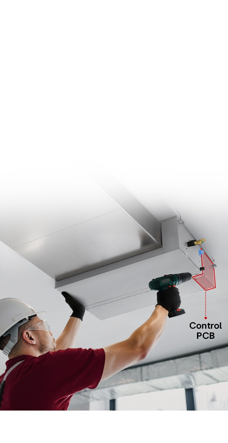A technician servicing a Ceiling Concealed Ducted Unit, accessing the control PCB through a bottom panel using a power drill.
