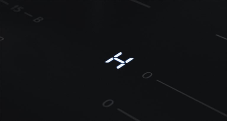 This is a close-up image of the "H" LED light, which is a residual heat indicator on the induction hob.