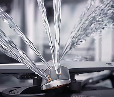Intense water streams from dishwasher blades in close-up.