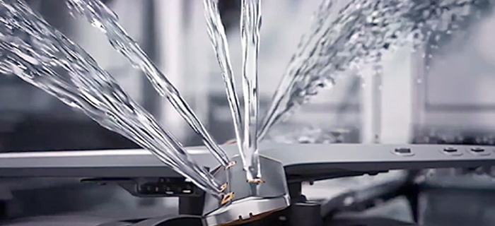 Intense water streams from dishwasher blades in close-up.