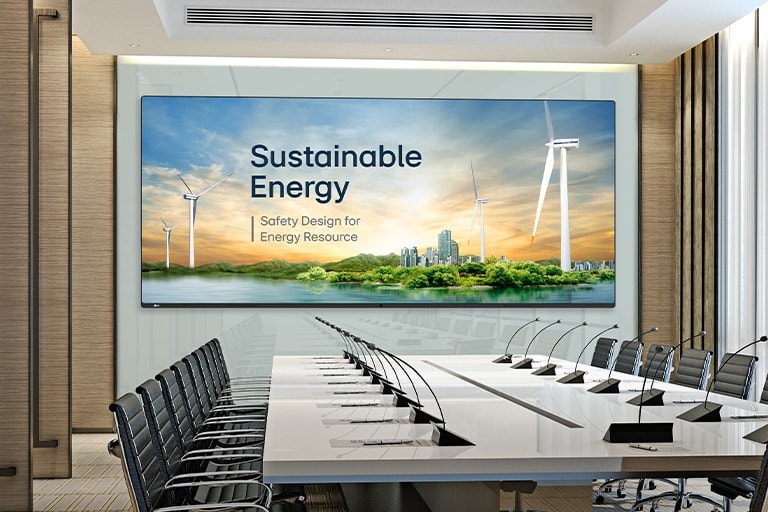 A wide display is installed on the wall of the spacious conference hall, and presentation is prominently and clearly displayed on the large screen.