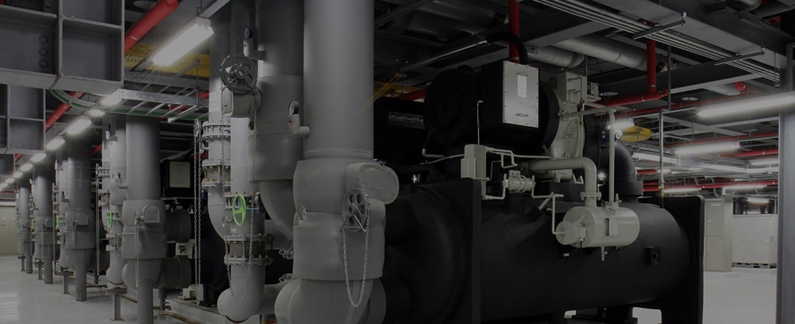 A substantial black-colored LG Chiller unit commands attention in a machine-filled room, its presence accentuated by gray-tone pipes.