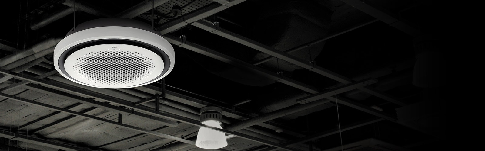 An LG Round Cassette air conditioner is displayed on a black ceiling with a complex network of pipes and beams.