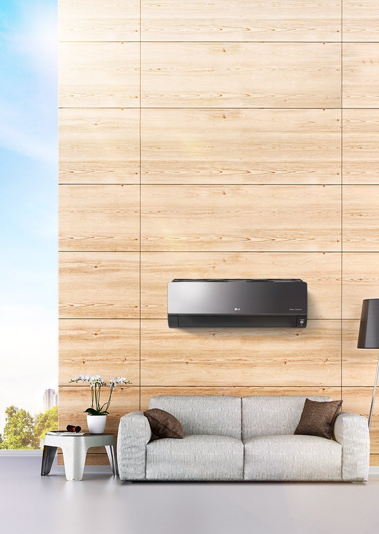 LG HVAC wall-mounted air conditioner unit with a black design in a modern room featuring a wooden wall and grey sofa.