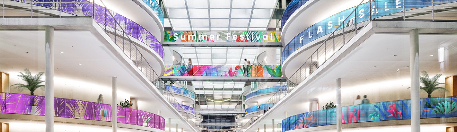 Transparent LED films are installed on the railings of several floors in the building. Even where the railing curves, the content of the transparent LED films is shown smoothly.