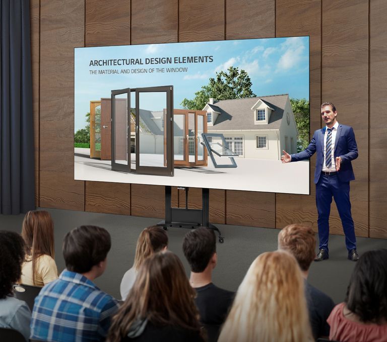 A man explains content on the screen of an LAEC installed with a dedicated stand in an auditorium.