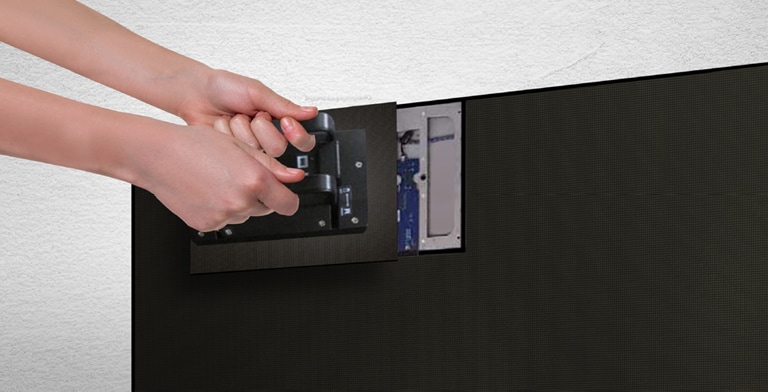 A person replaces one of the LED modules from the front by using the magnetic tool provided.