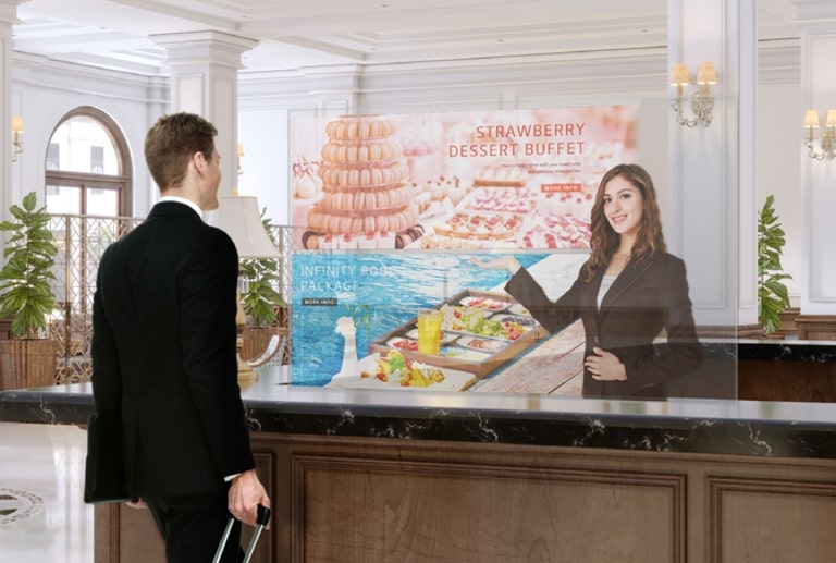 A man is getting information through the Transparent OLED screen showing photos of the dessert menu.