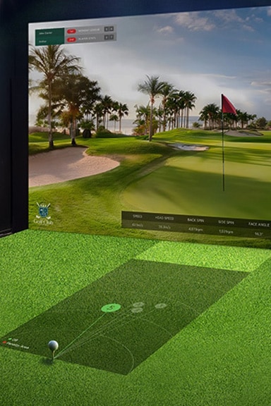 A golf simulator with moderate brightness; the projected screen appears dim and less vibrant, reducing visual clarity.	