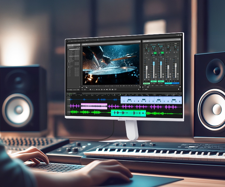 LG Smart Monitor displaying a professional video and audio editing workspace with timeline, color grading tools, and sound mixing interface, highlighting IPS 4K resolution, HDR support, and wide color coverage in a creative studio setup with speakers and keyboard for content production and multimedia work.