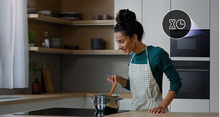 A woman who cooks comfortably with microwave oven's kitchen timer.