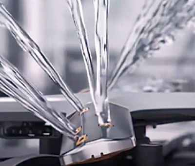 Intense water streams from dishwasher blades in close-up.