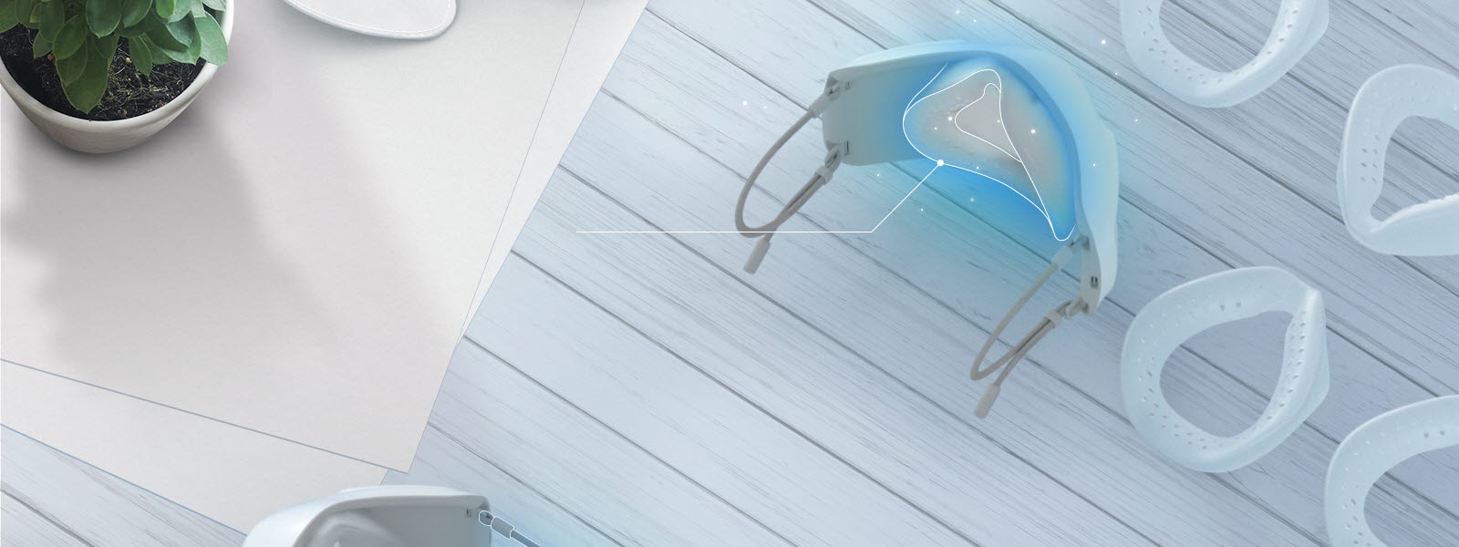 The top and slight interior of the mask is shown with the inner cover inside and silicone pads are spread on the table around it. The place to put the silicone pad inside is highlighted in blue.