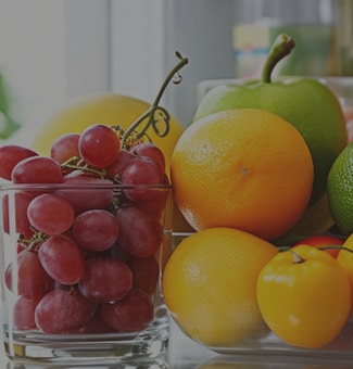 Close up view of an lg multi door refrigerator with various fresh fruits and vegetables.