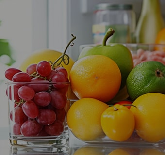 Close up view of an lg multi door refrigerator with various fresh fruits and vegetables.