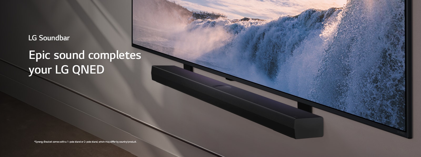 Sound barLG TV and Soundbar are placed within an angled perspective mounted on a wall. On the TV, a close up of a vast waterfall is displayed, and soft sunlight cascade over the wall, TV, and soundbar. A disclaimer reads: "Synergy Bracket comes with a 1-pole stand or 2-pole stand, which may differ by country/product."