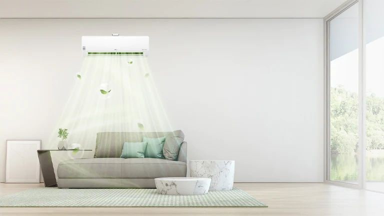 An LG wall-mounted unit breathes a leaf-filled, green airflow onto a couch below, as twin marble tables are displayed nearby. 