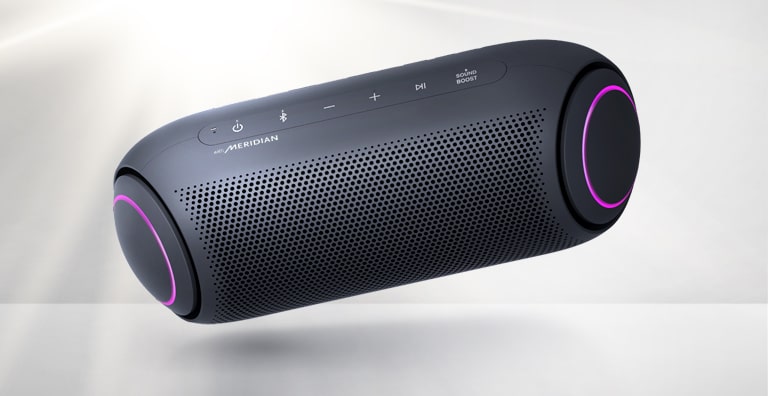 LG XBOOM Go tilts to the left and floats in the air. The woofer lighting is magenta.