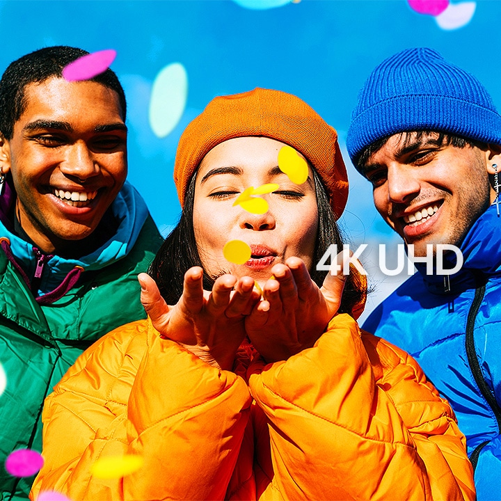 Three people wearing green, yellow, and blue outfits.	
