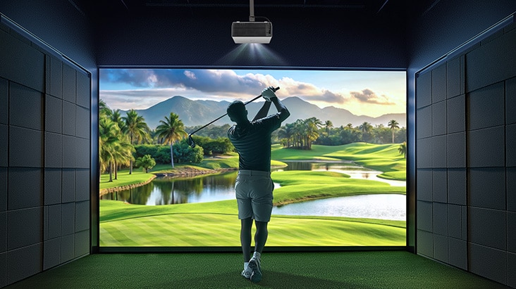 A golfer swinging in a golf clubhouse with a screen displayed using an LG projector.	
