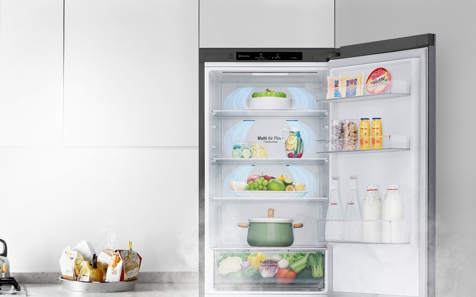 The top half of the refrigerator is shown with the door open and produce inside. Air flows from the top down and throughout the fridge reaching all of the food inside.