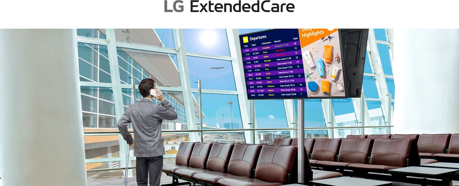 A traveler stands in an airport lounge, checking his phone while looking at a digital departure board displaying flight schedules. The scene highlights the modern, efficient use of signage for real-time updates.