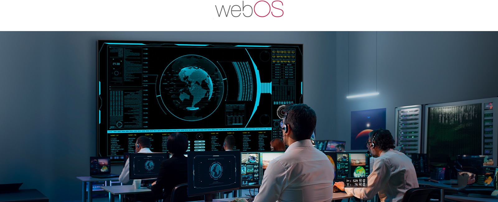 This image shows several people monitoring multiple displays in a control room.