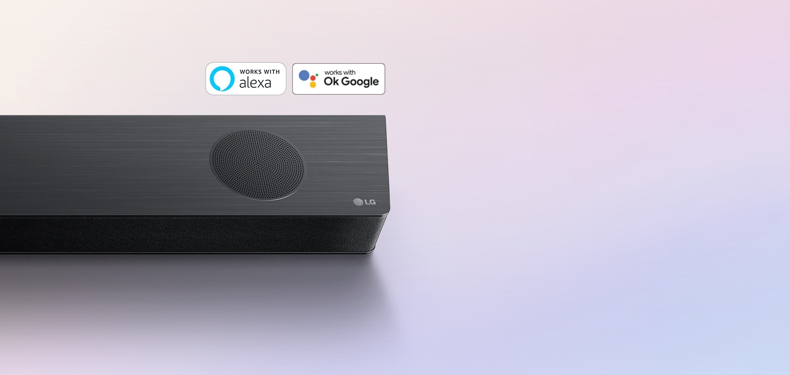 LG Sound Bar is place on the ground, showing LG logo right corner of the sound bar. Alexa logo and OK GOOGLE logos are placed on the sound bar.