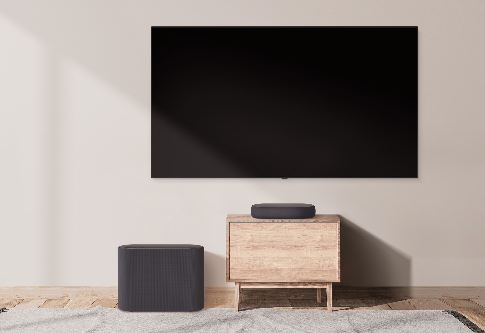 There is a bulky soundbar placed on a wide cabinet and a subwoofer placed on the left. The scene changes and a compact soundbar appears on a smaller cabinet and a subwoofer placed on the left. 