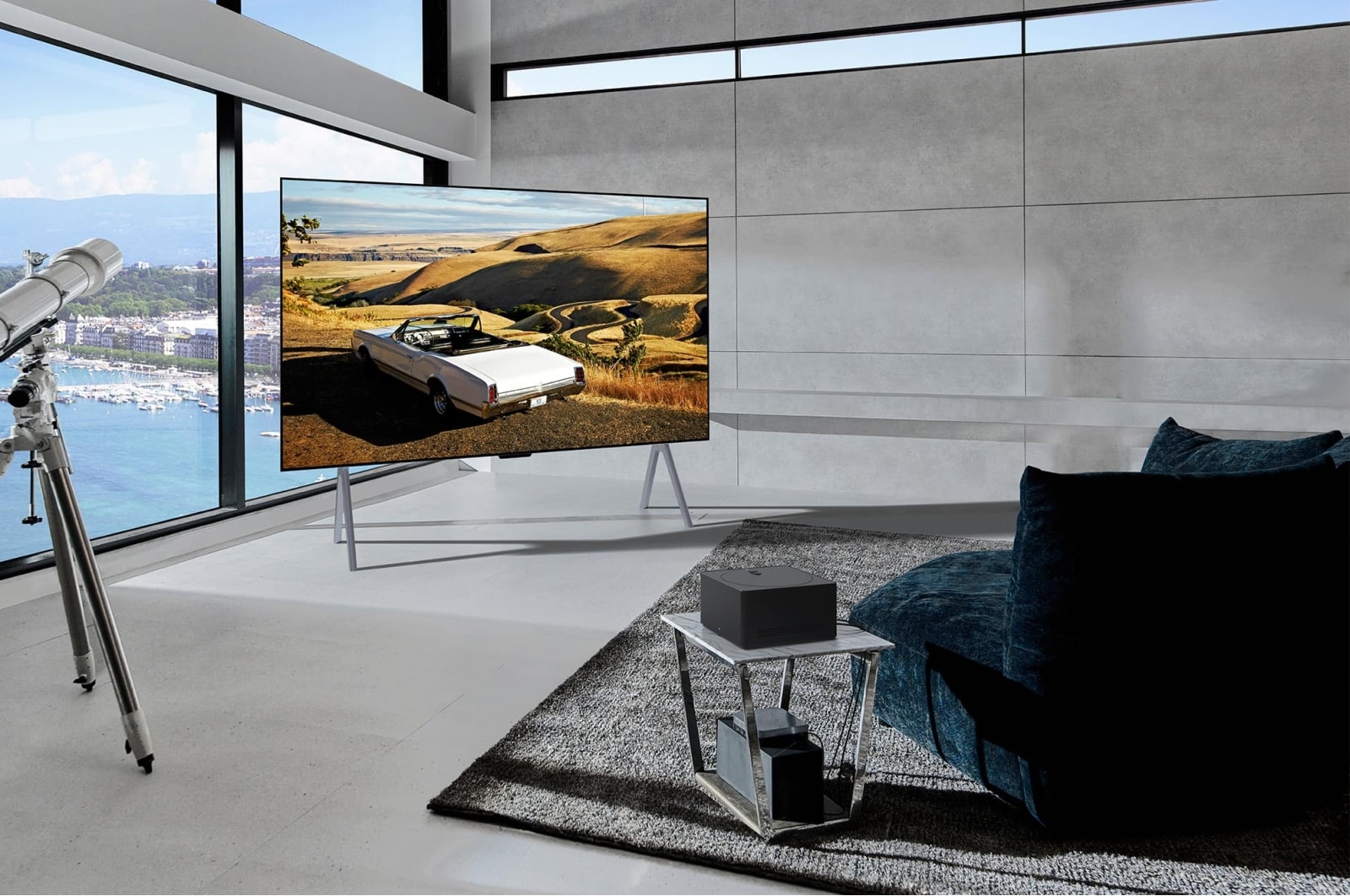 LG True Wireless TV 97 inch LG SIGNATURE OLED M4 with 4K 120Hz Video & Audio Transfer , An LG SIGNATURE OLED M4 with a scenic image on the screen stood on a marble floor against a floor-to-ceiling window in a modern living space, and a Zero Connect Box on a small table in front with devi, OLED97M46LA