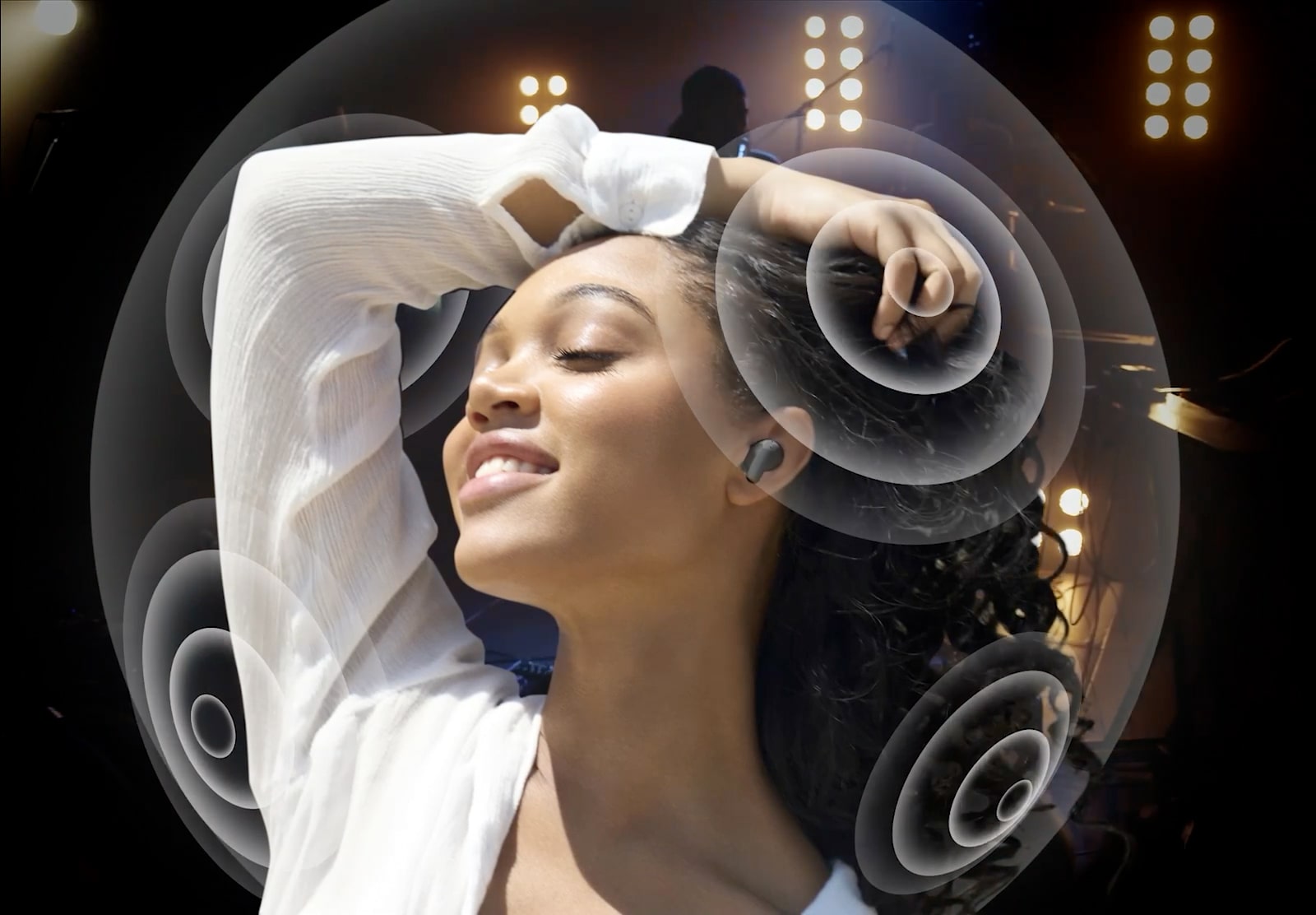 A woman is using her phone and listening to music with T90. The scene around her changes to a concert with sound waves showing the Dolby Atmos sound.