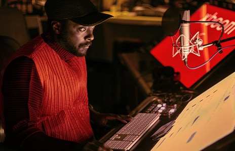 will.i.am is working in a studio watching monitors.