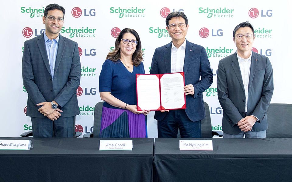 LG and Schneider Electric leaders holding signed document at the official ceremony