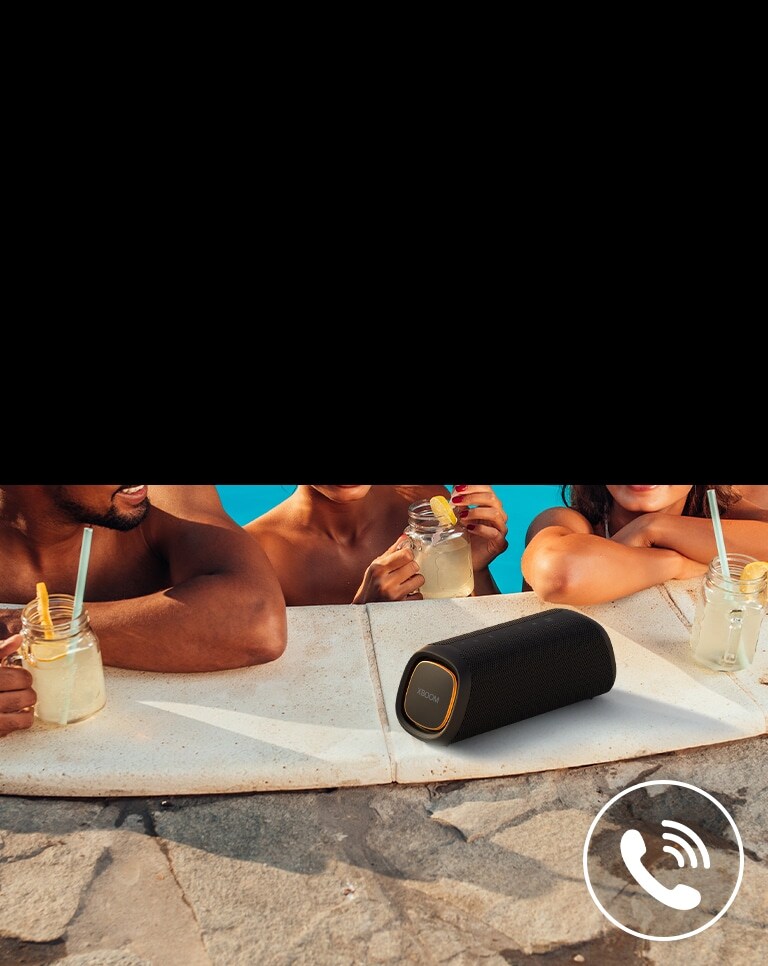 تم وضع LG XBOOM GO XG7 بجانب المسبح. ثلاثة أشخاص يتحدثون من خلال مكبّر الصوت في المسبح.