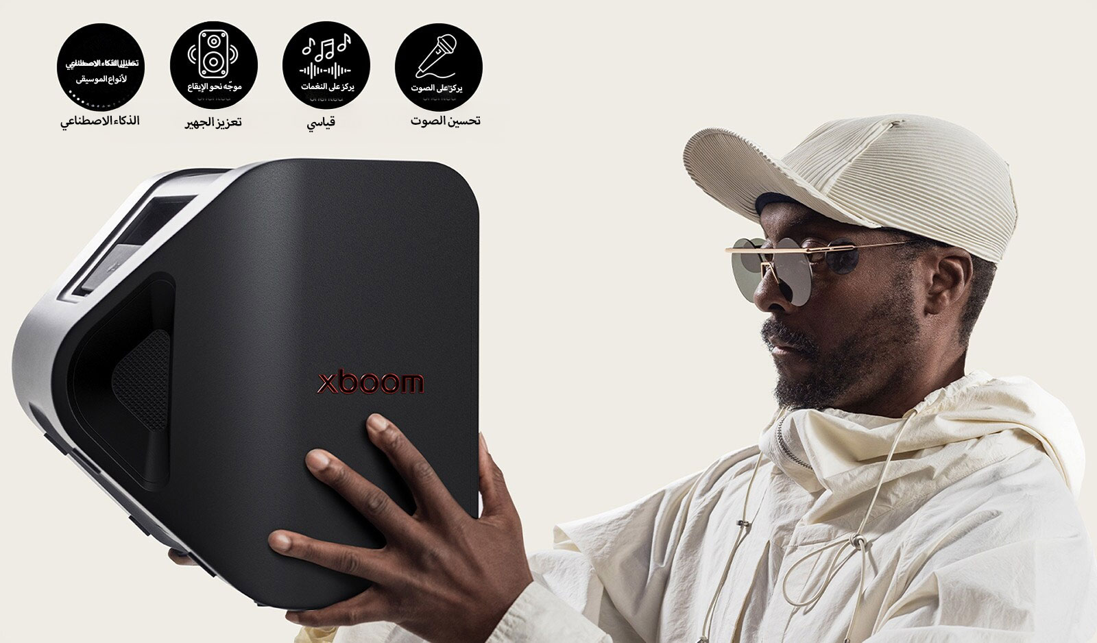 يظهر will.i.am مرتديًا زيًا أبيض وقبعة بيضاء، وهو يحمل جهاز xboom Stage 301 بكلتا يديه قرب وجهه.