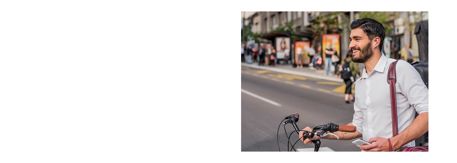 رجل يدفع دراجته في المدينة وهو يرتدي سماعات الأذن.