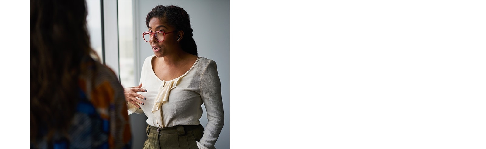 امرأتان تتحدثان. المرأة المواجهة للخارج ترتدي سماعات الأذن.