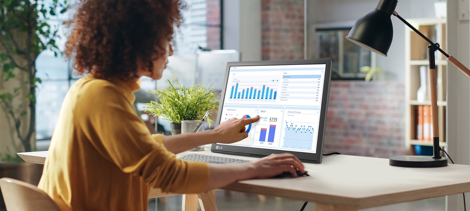 أمرأة تلمس شاشة LG SXGA التي تعمل باللمس.