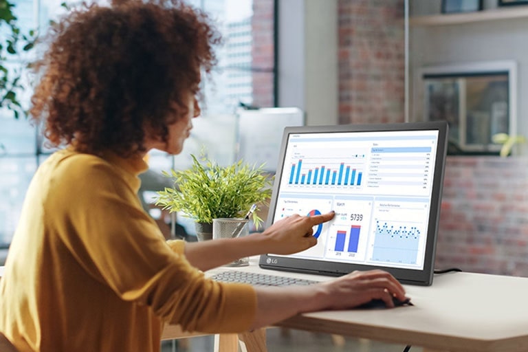 أمرأة تلمس شاشة LG SXGA التي تعمل باللمس.