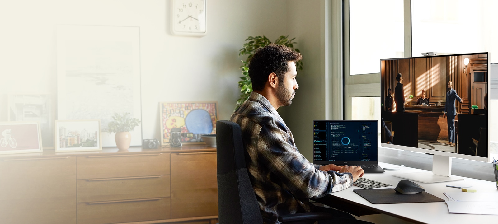 رجل يستمتع ببث المحتوى على شاشة LG MyView Smart Monitor أثناء انتظار اكتمال مهام الكمبيوتر المحمول.	