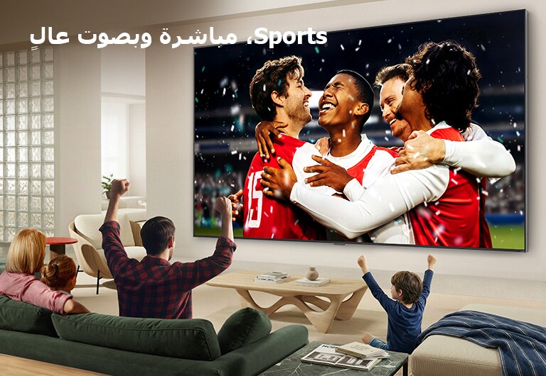 يُعرض تلفزيون LG Ultra Big TV مثبتًا على الحائط في غرفة معيشة مشرقة، حيث يُظهر احتفالًا رياضيًا في الاستاد بألوان نابضة بالحياة وجودة صورة مصقولة على شاشة عريضة، بينما تشجّع عائلة جالسة على الأرائك معًا.