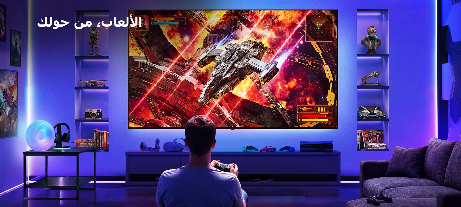 تلفزيون LG Ultra Big TV مثبت على الحائط في غرفة ألعاب مضاءة بالنيون، حيث تعرض شاشة كبيرة مشهد معركة في مساحة نابضة بالحياة بينما يجلس اللاعب أمام الشاشة، مما يوضح تجربة ألعاب غامرة وجذابة.
