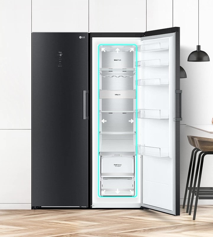 تُعرض الثلاجة من الأمام داخل المطبخ وبابها مفتوح لتُظهر محتوياتها من المنتجات الغذائية. يبرز مربع أزرق الجزء الداخلي، مع أسهم متجهة إلى الخارج للدلالة على اتساع المساحة الداخلية.