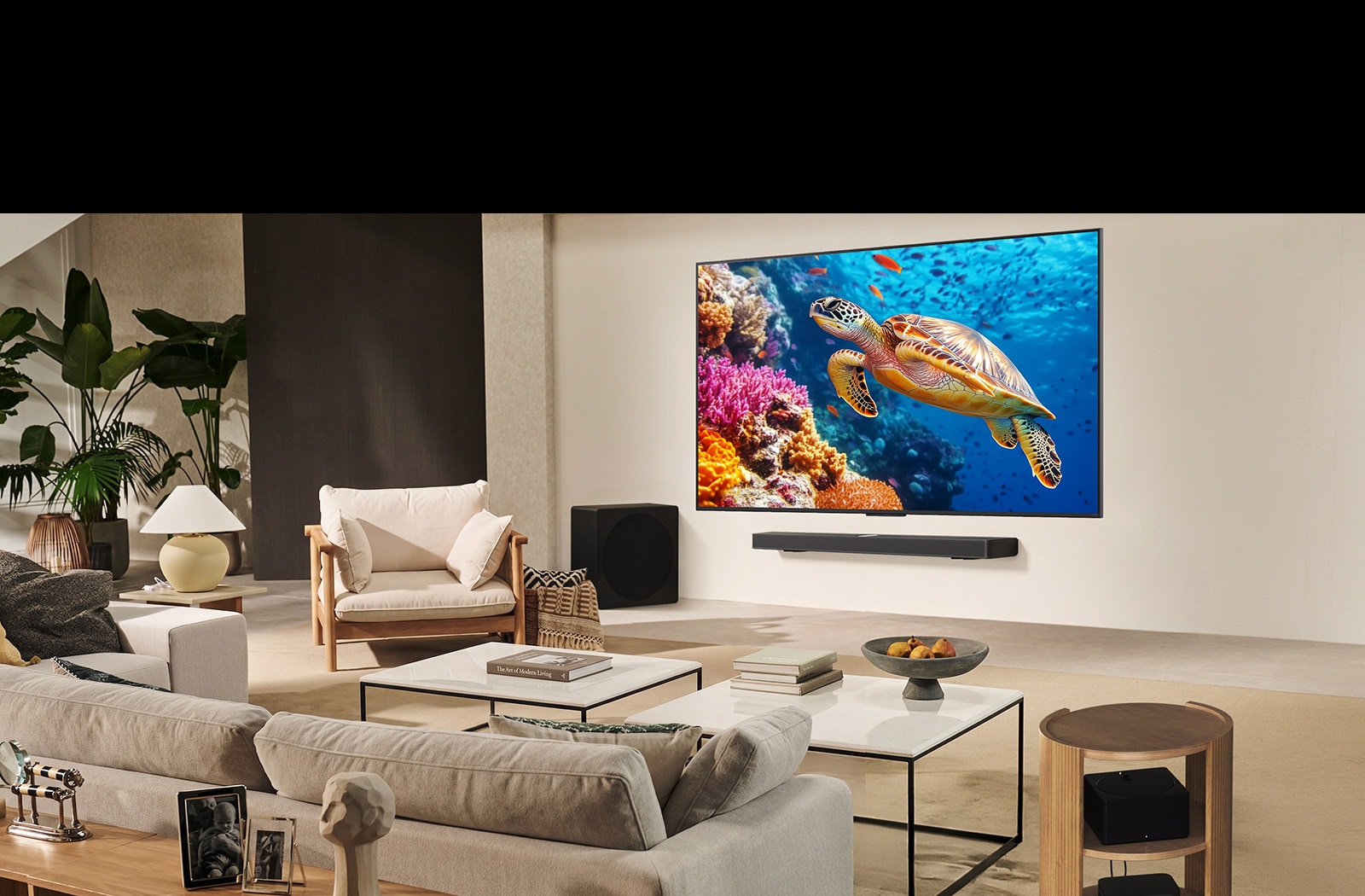 عائلة تجلس على أريكة تواجه تلفزيون LG TV مثبت على جدار فوق مكبر الصوت LG Soundbar. يظهر صندوق Zero connect box داخل طاولة القهوة.